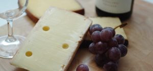 Hard cheese and grapes on board