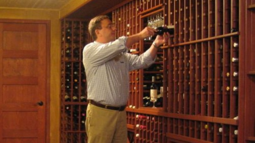 wine collector enjoying his bottles in cellar collection