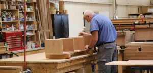 master carpenter works to make cabinets for wine cellar at Rosehill woodshop