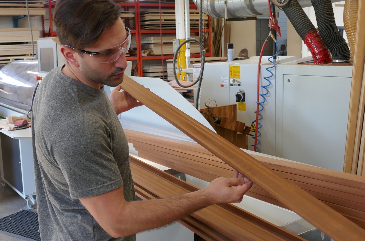woodworker checks crown moulding from Weinig Variomat 