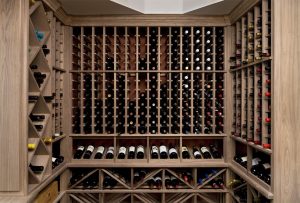 Wine cellar construction with arranged wine bottles.