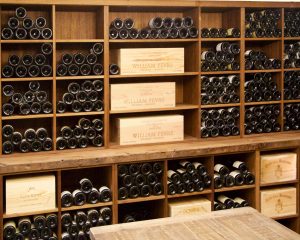Hundreds of wine bottles stored on beautiful wooden wine racks.