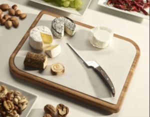 Cheese board with an assortment of cheeses and a cheese knife.